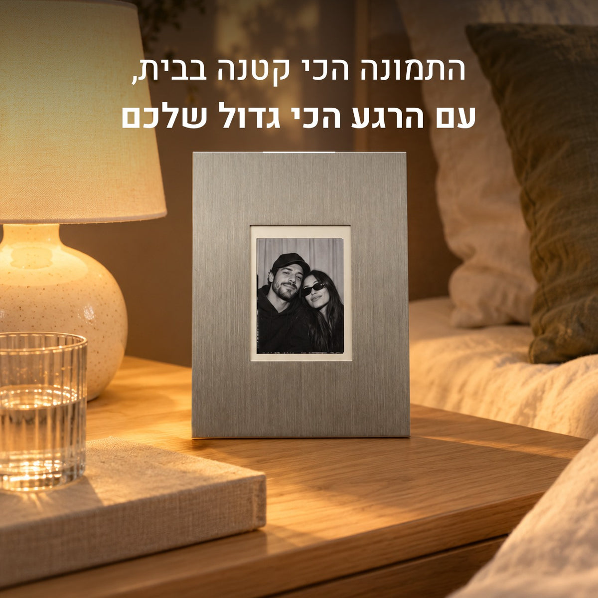 מסגרת נירוסטה על שידה ליד מנורה